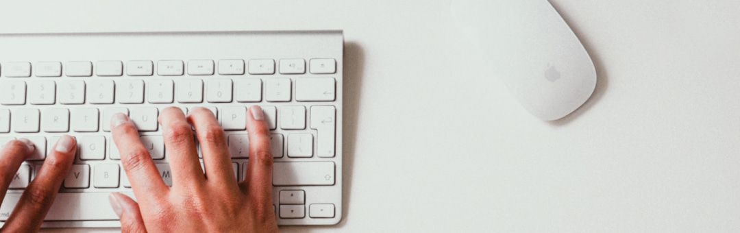 Imagem de uma mão sobre um teclado de computador.